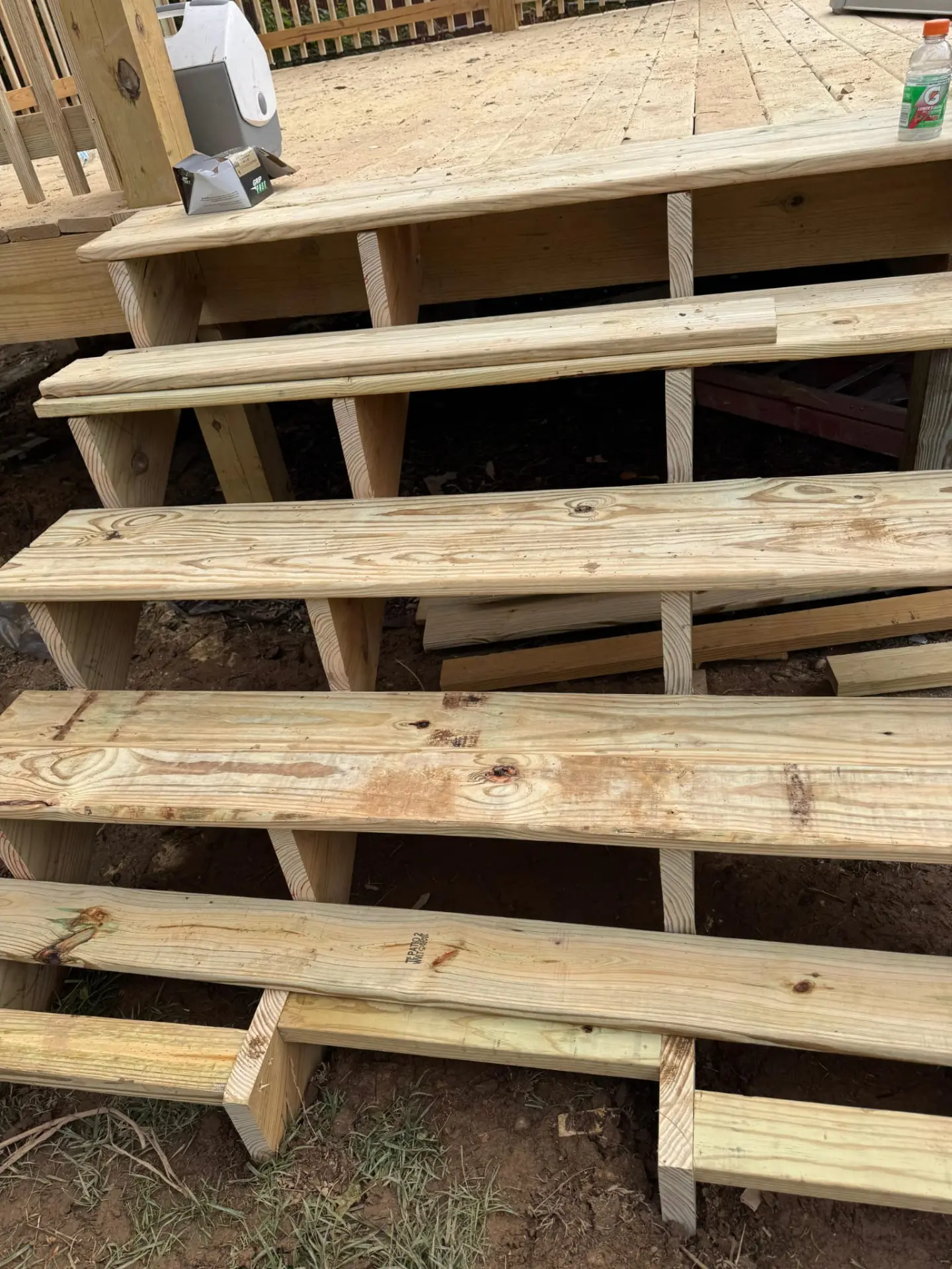 Pressure-treated timber deck steps framed and boarded leading up to a new patio deck