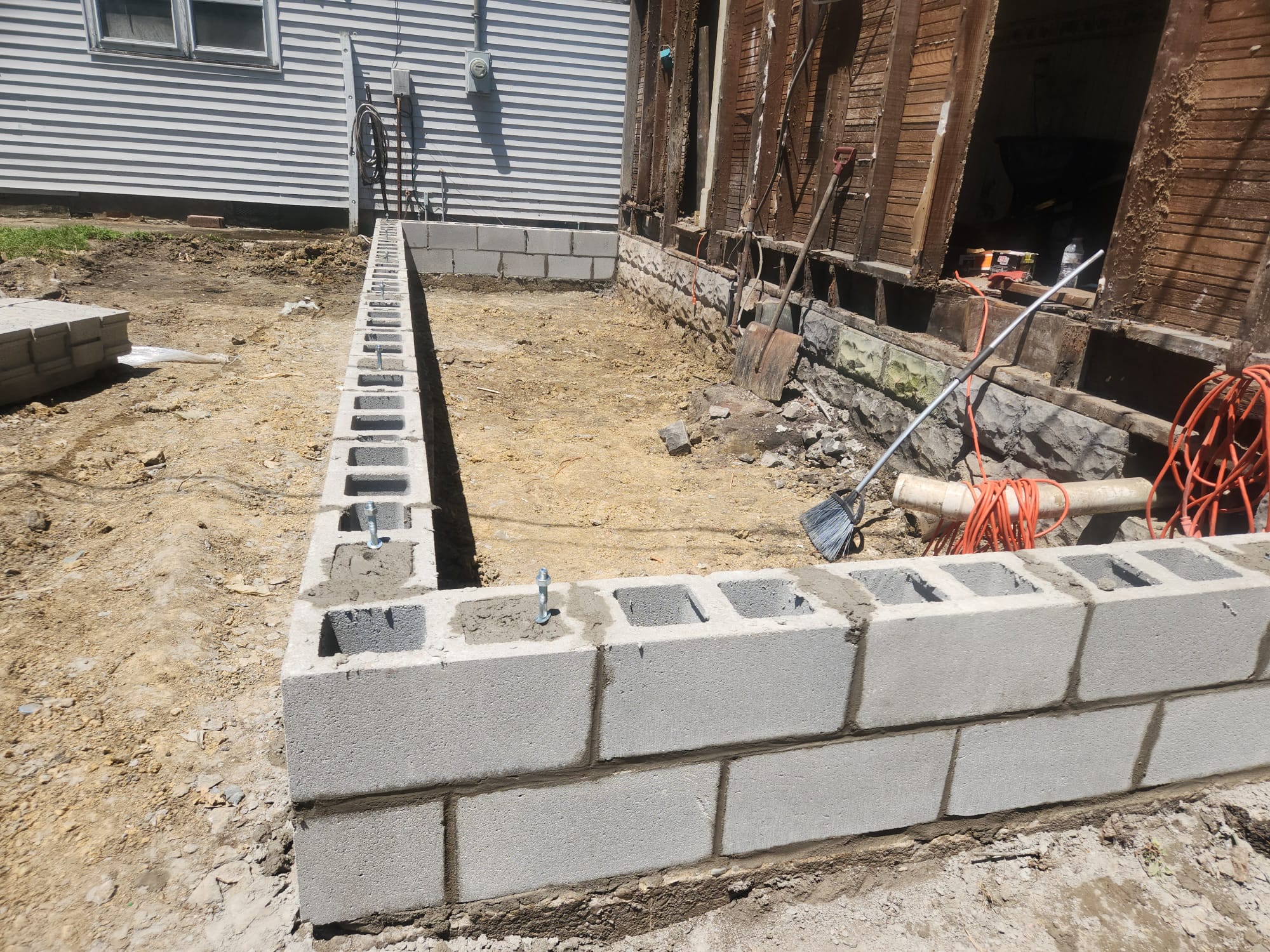 Concrete block foundation wall laid to course with anchor bolts set in the top cells