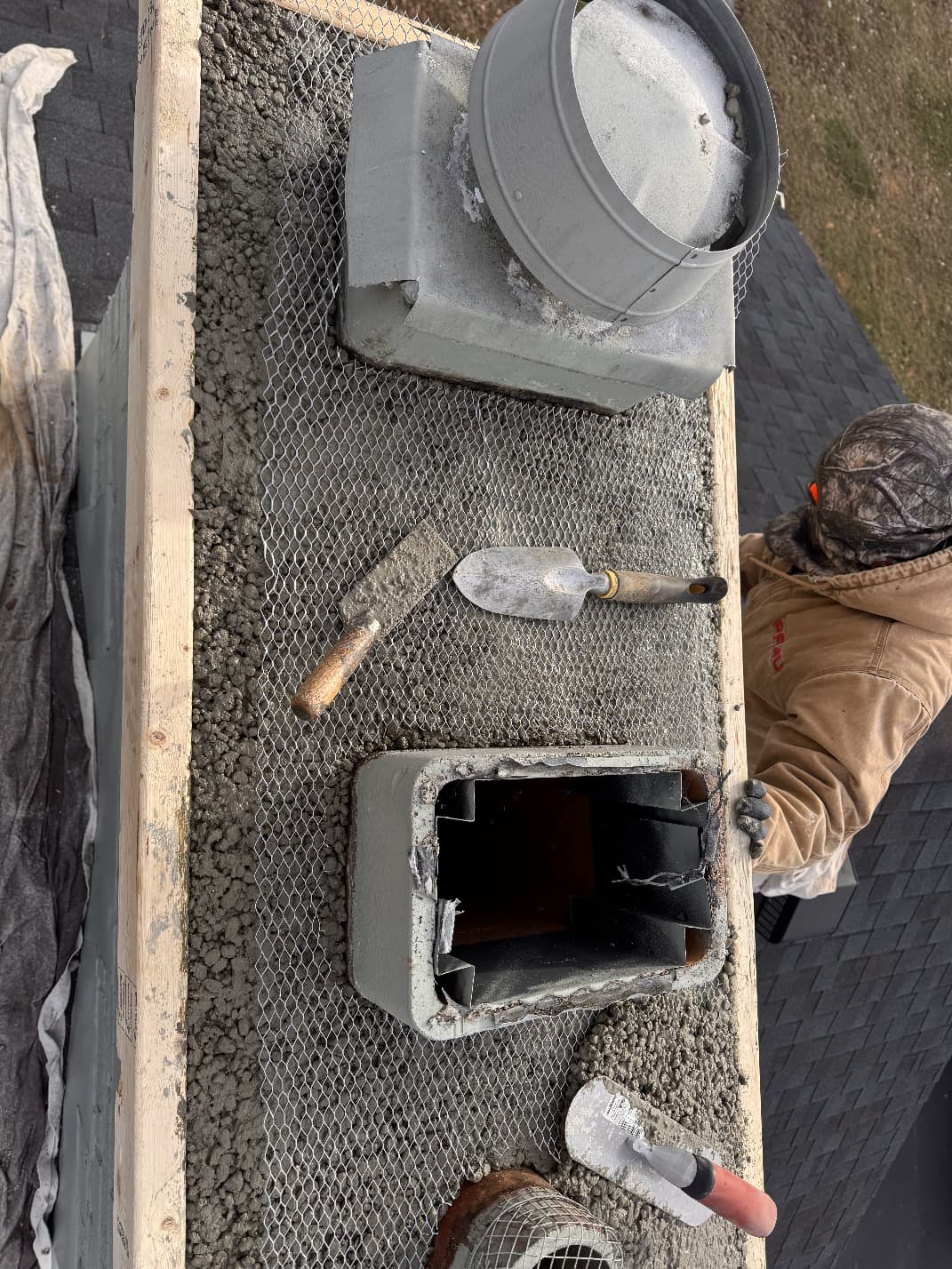 New chimney crown poured over wire mesh inside timber formwork around the flue and vent