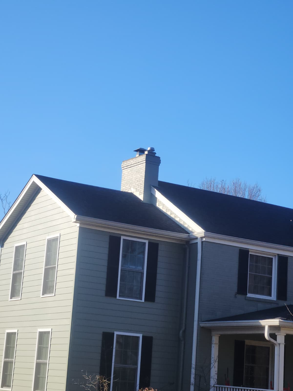 After: rebuilt and painted chimney with a new cap standing clean above the roofline