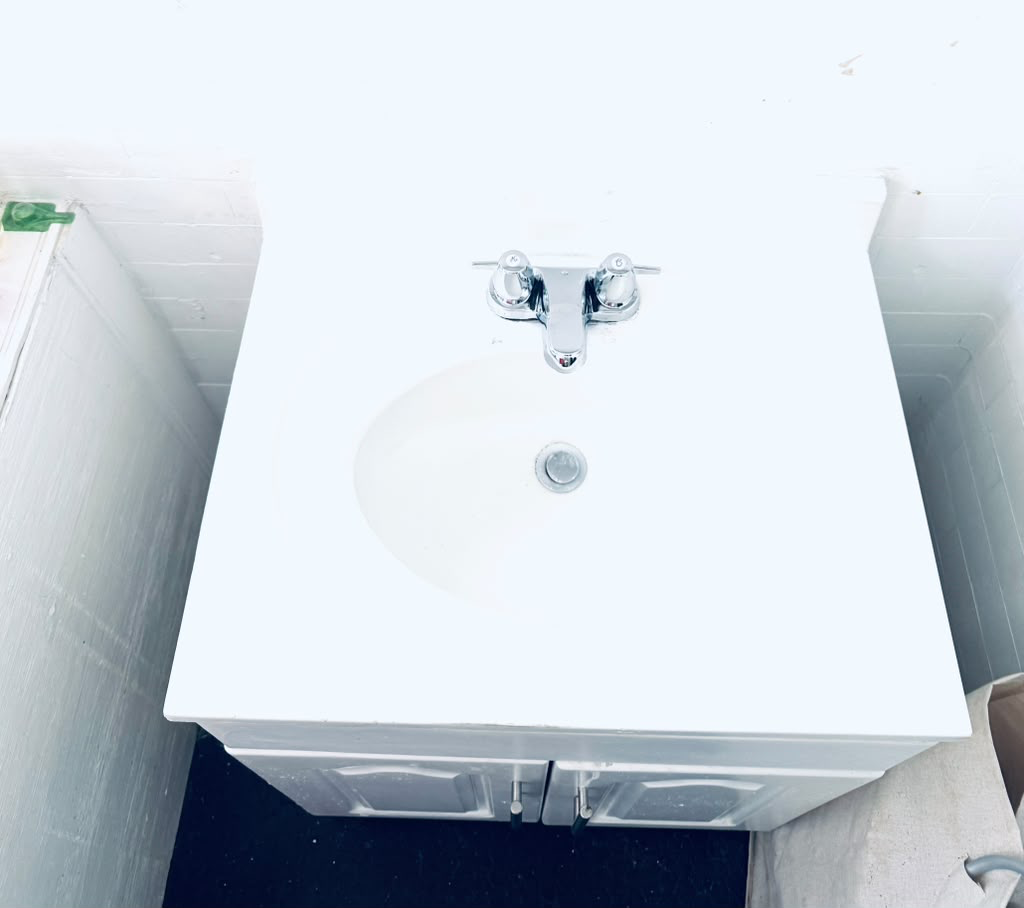 Newly installed white bathroom vanity top with a fresh chrome two-handle faucet and clean basin
