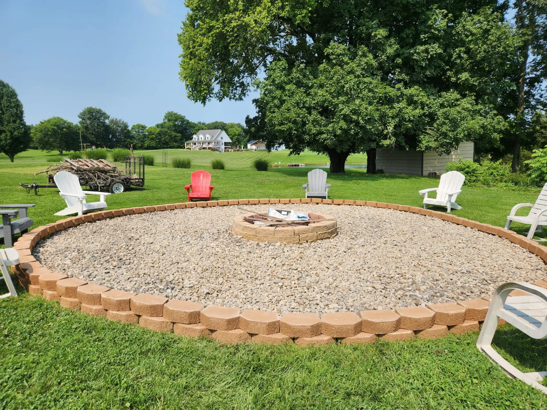 After: repaired lawn with a new circular paver fire-pit patio ringed in stone edging
