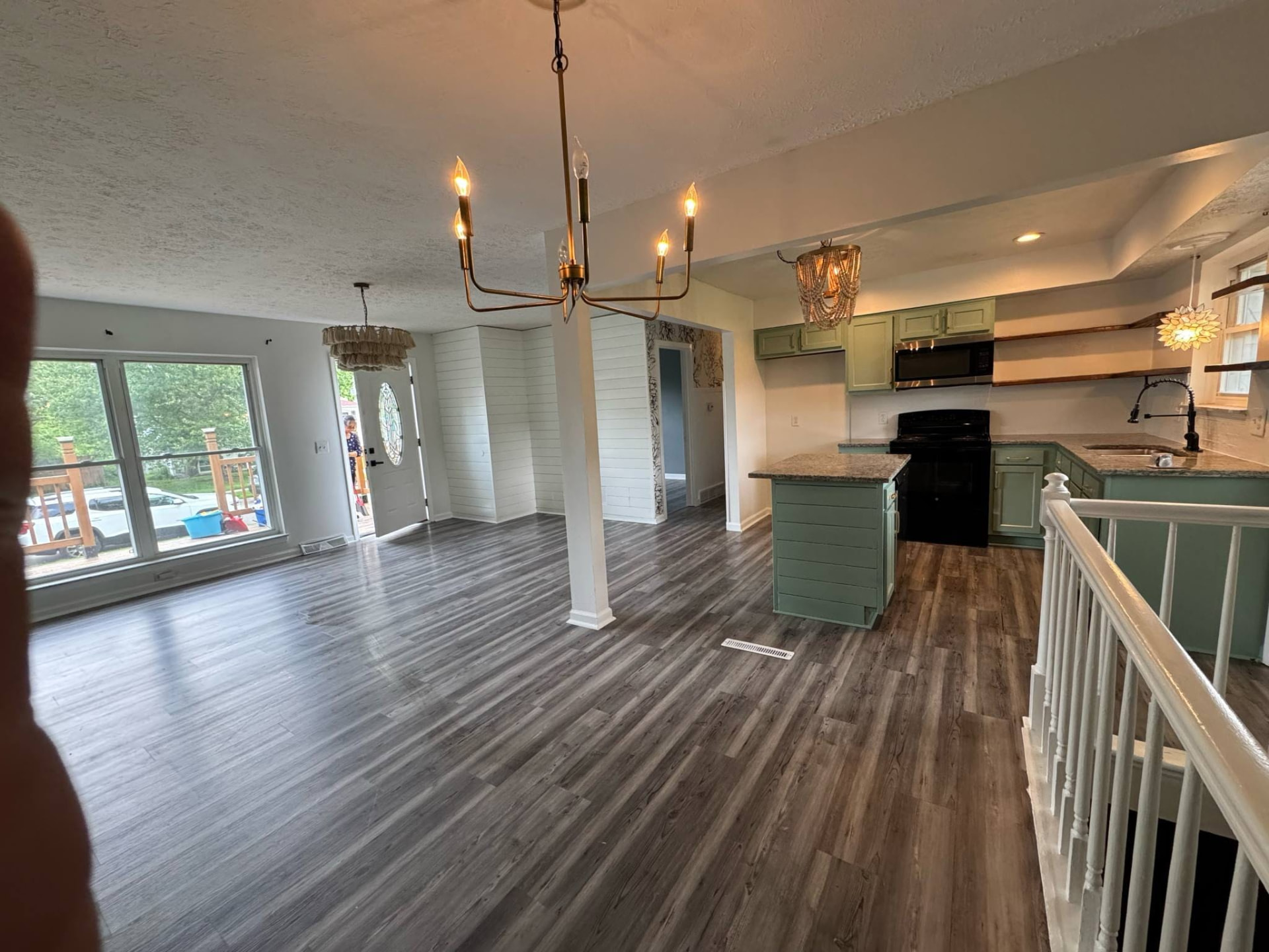 Completed open-plan living, dining and kitchen renovation by BapuHomes with grey plank flooring and shiplap feature wall