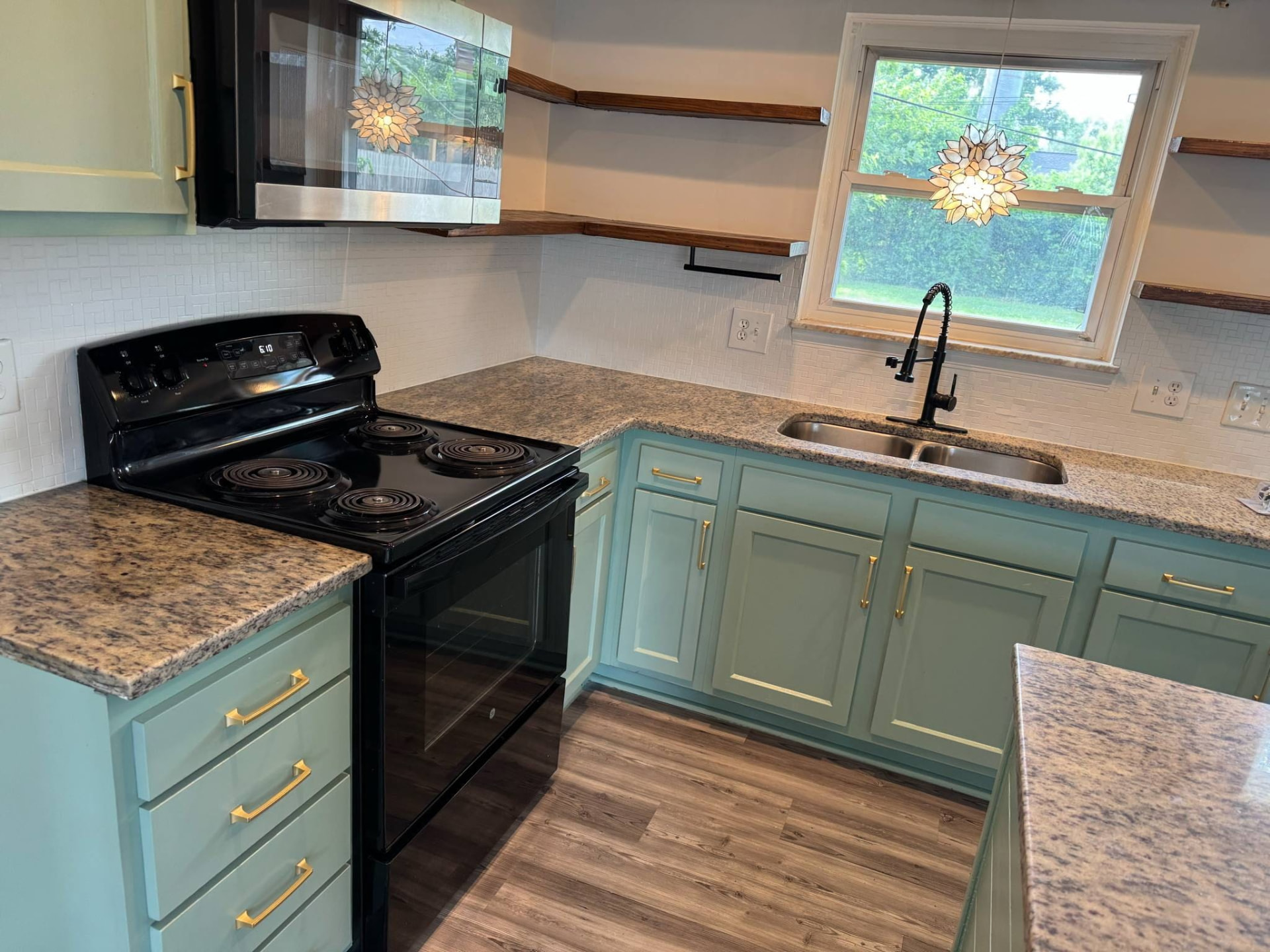 Granite worktop detail with tiled backsplash, black matte tap and new range
